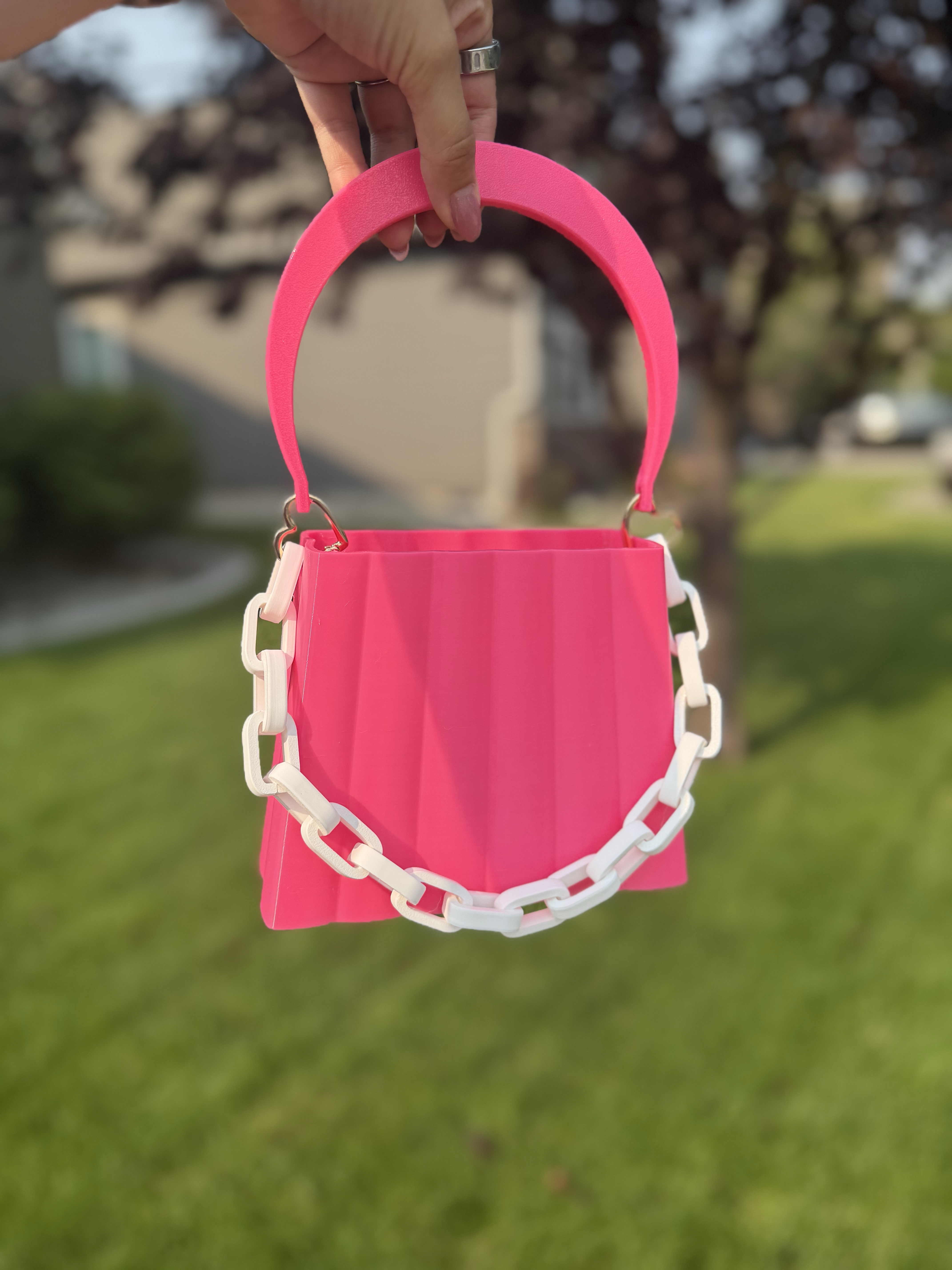 Bright pink 3D-printed Kindle purse with a white chain strap