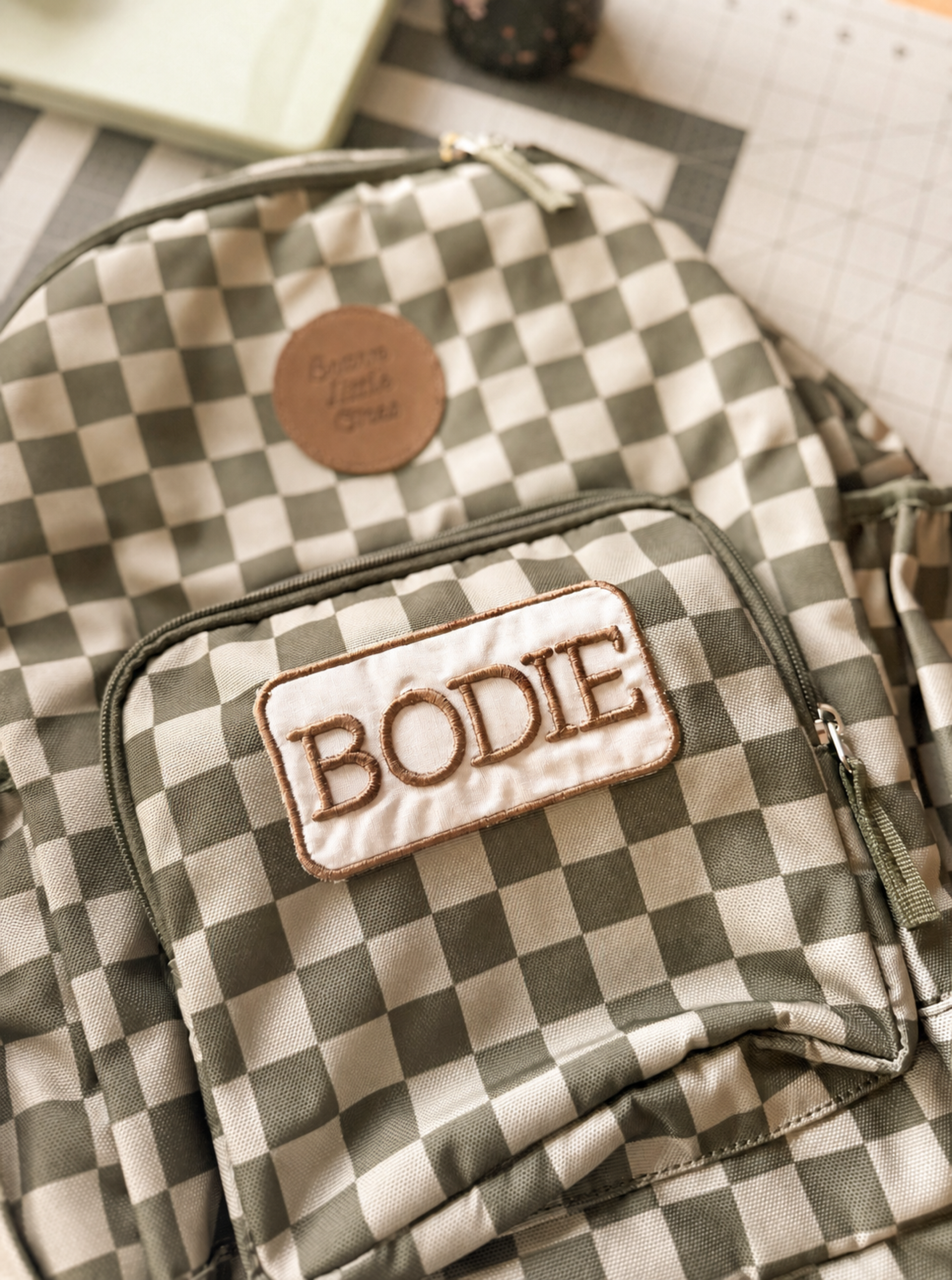 Custom embroidered BODIE name patch on a green and ivory checkerboard bag
