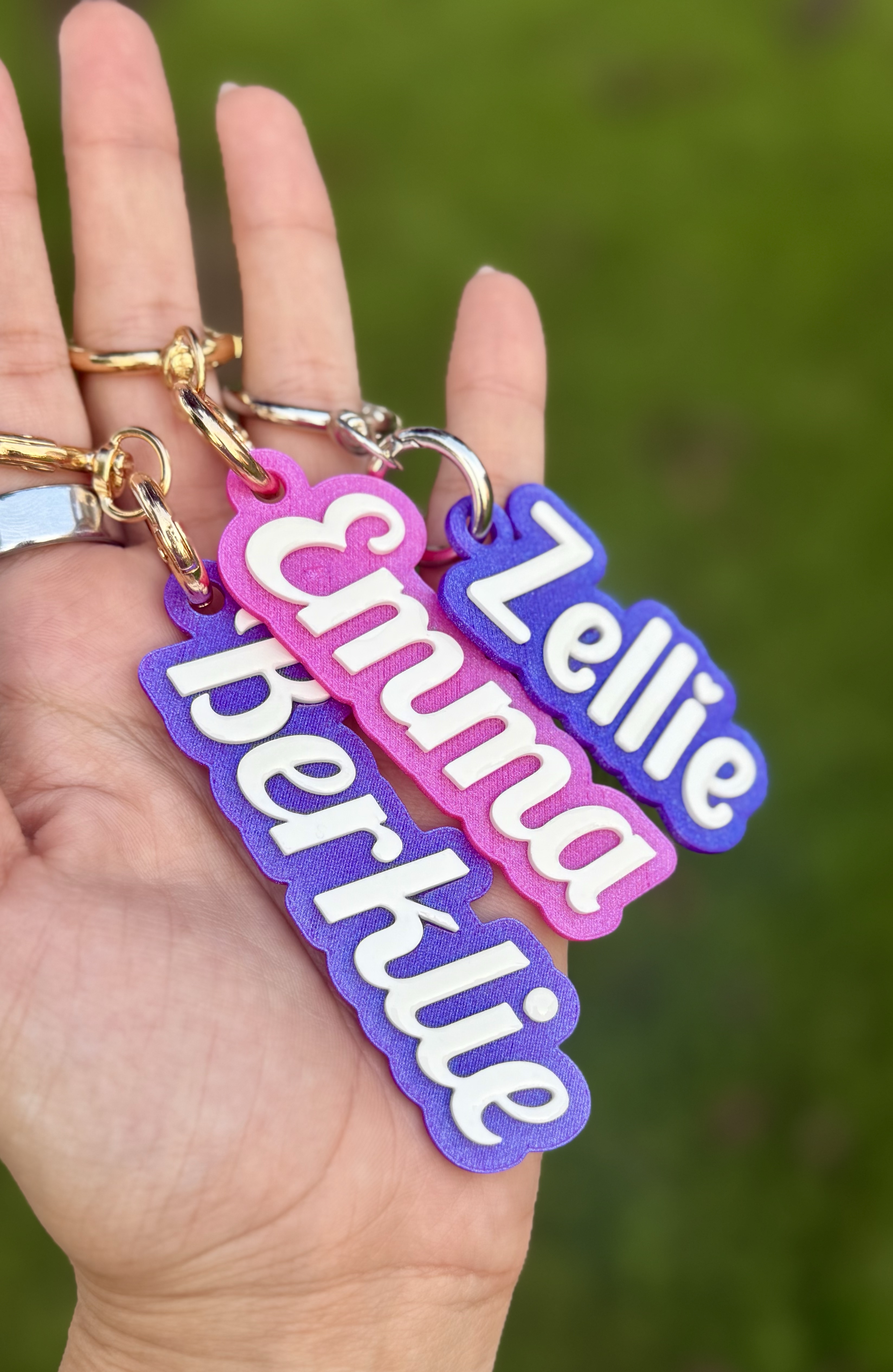 Colorful personalized name keychains held in one hand