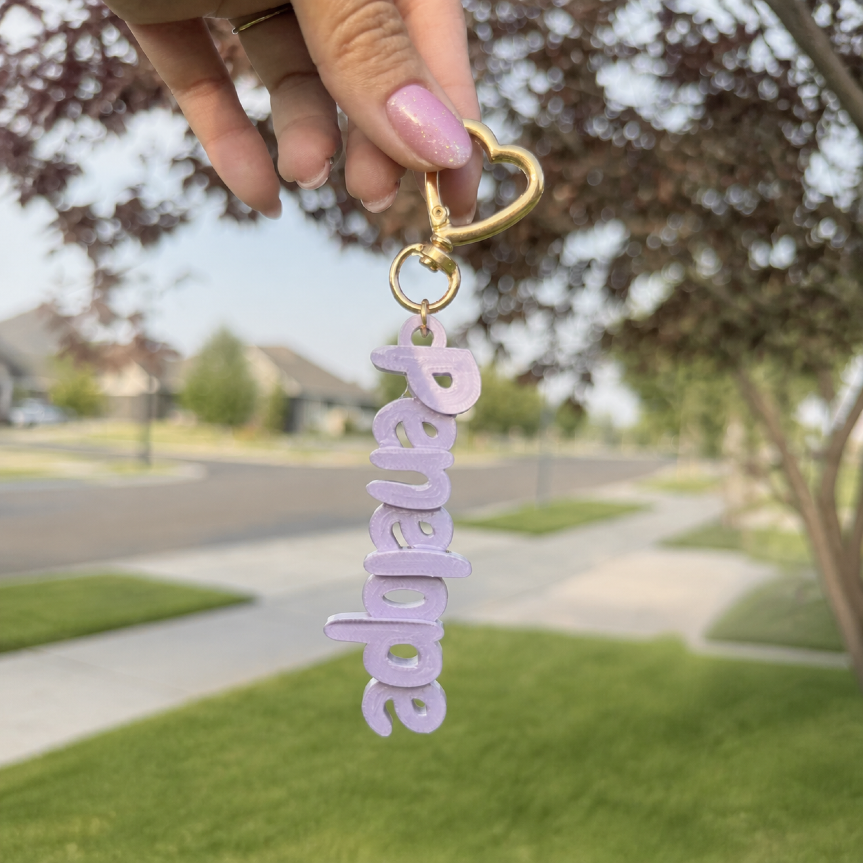 Lavender custom name keychain spelling Penelope with gold heart-shaped hardware