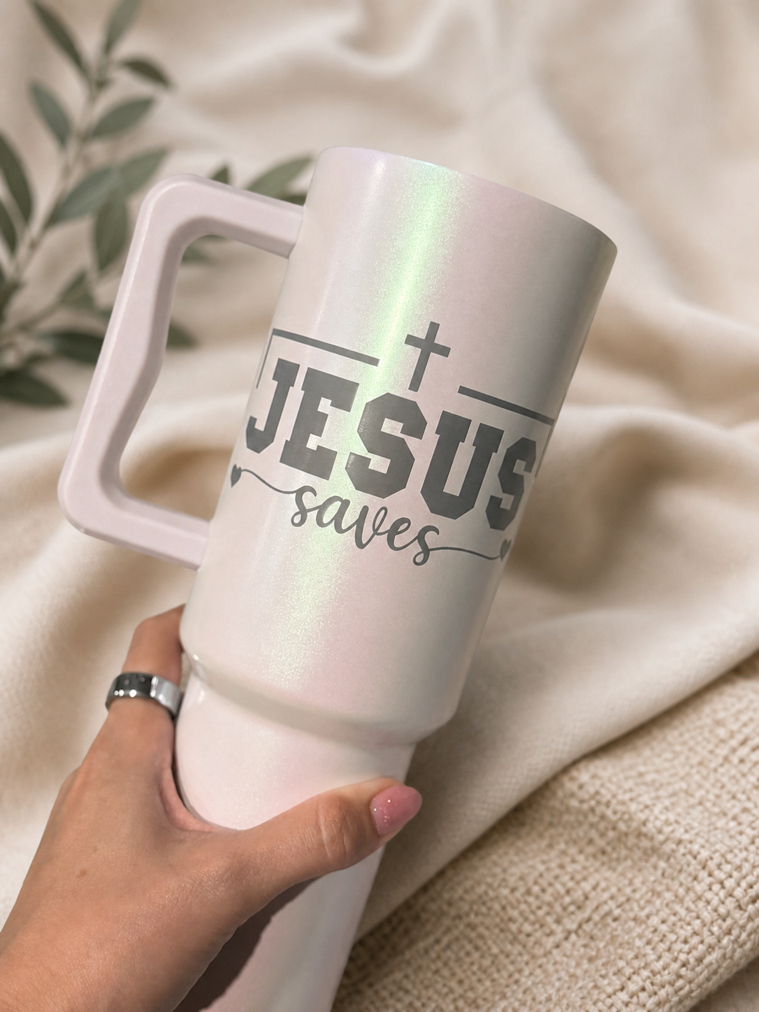 Pearlescent blush handled tumbler engraved with a Jesus saves design and styled with natural woven accents