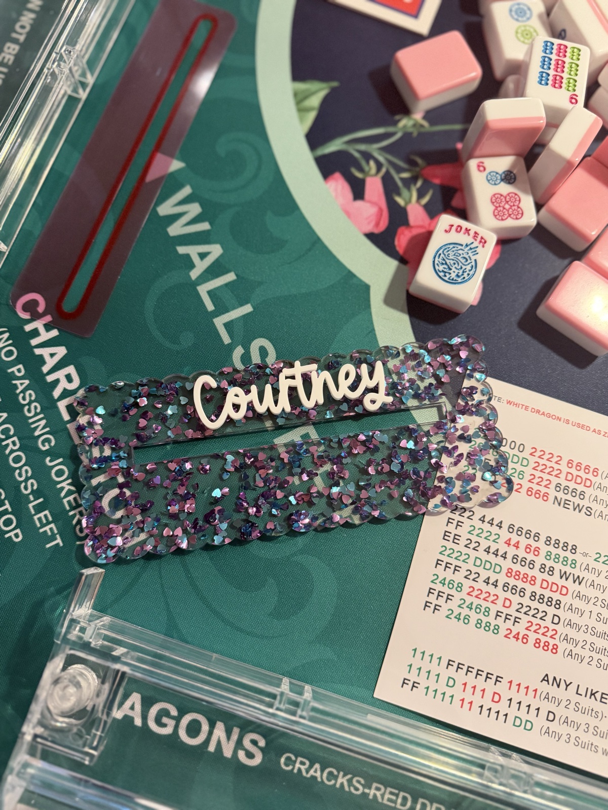 Close-up of the Courtney heart glitter mahjong card holder beside pink mahjong tiles