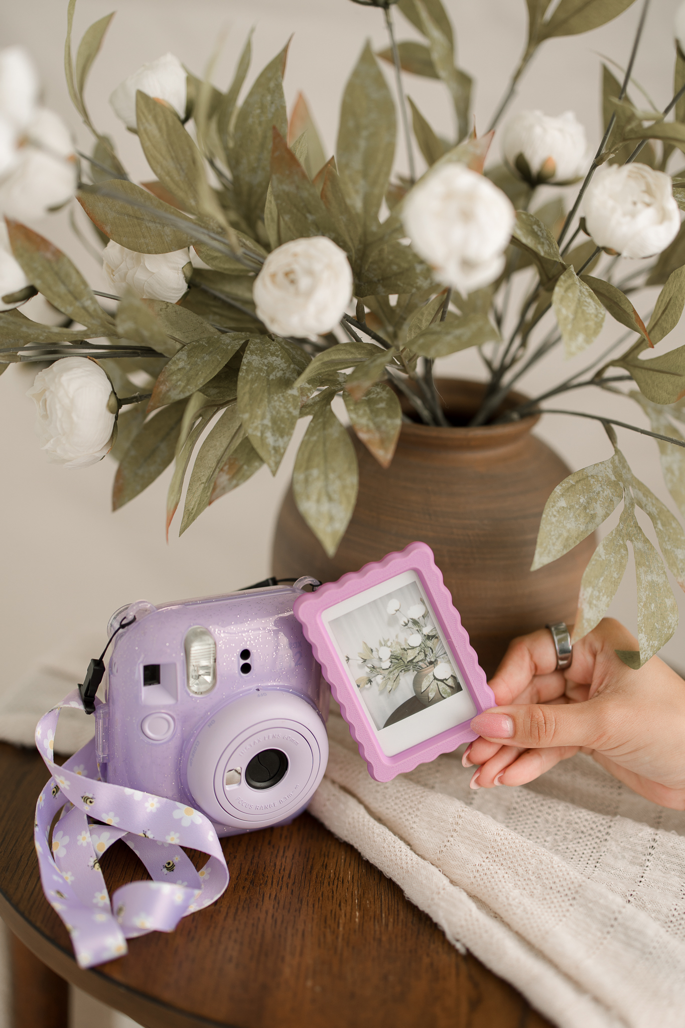 Custom scalloped instant photo frame beside a lavender camera