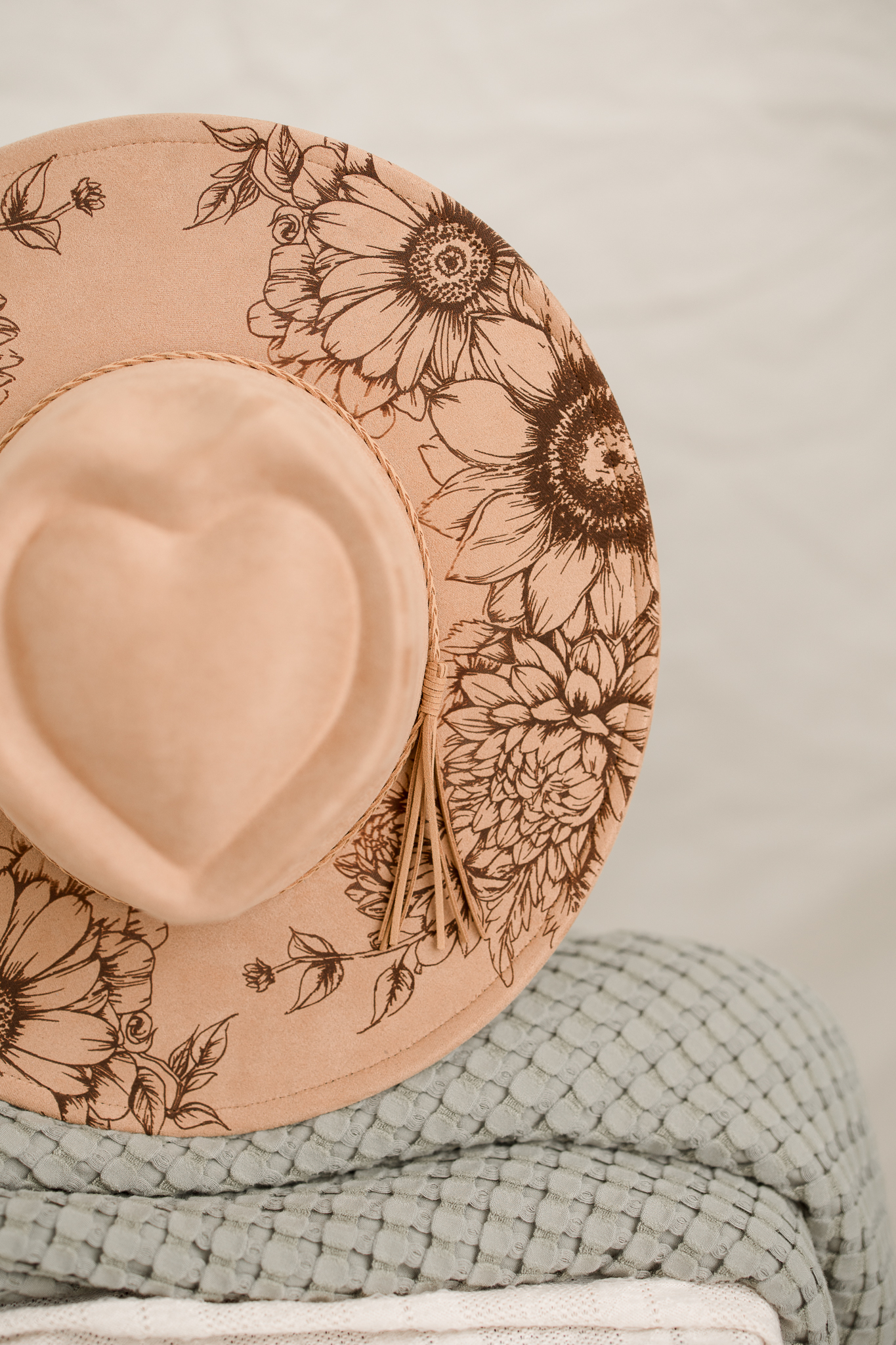 Detailed floral artwork on a blush hat